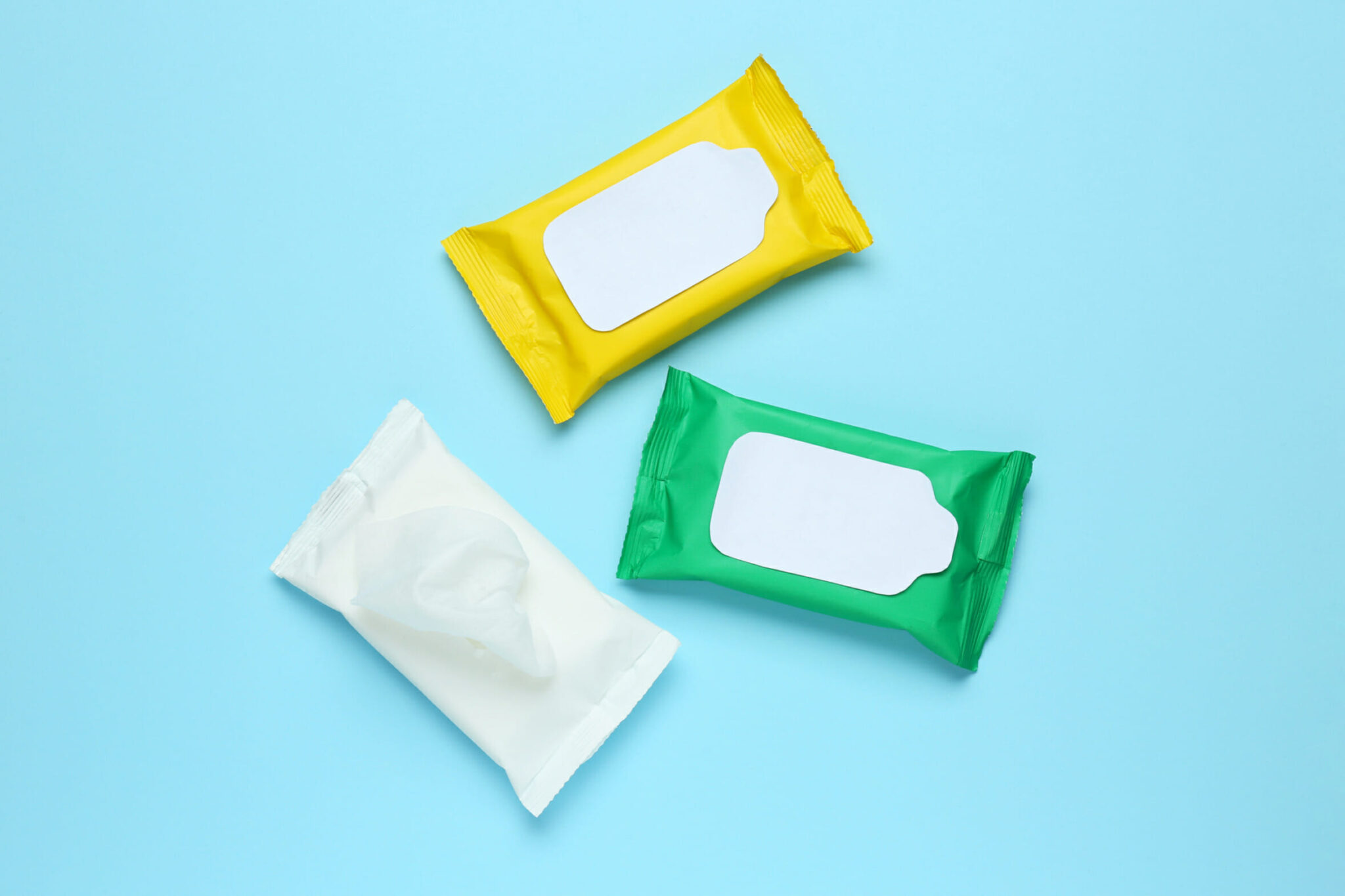 Wet wipes flow packs on light blue background, flat lay