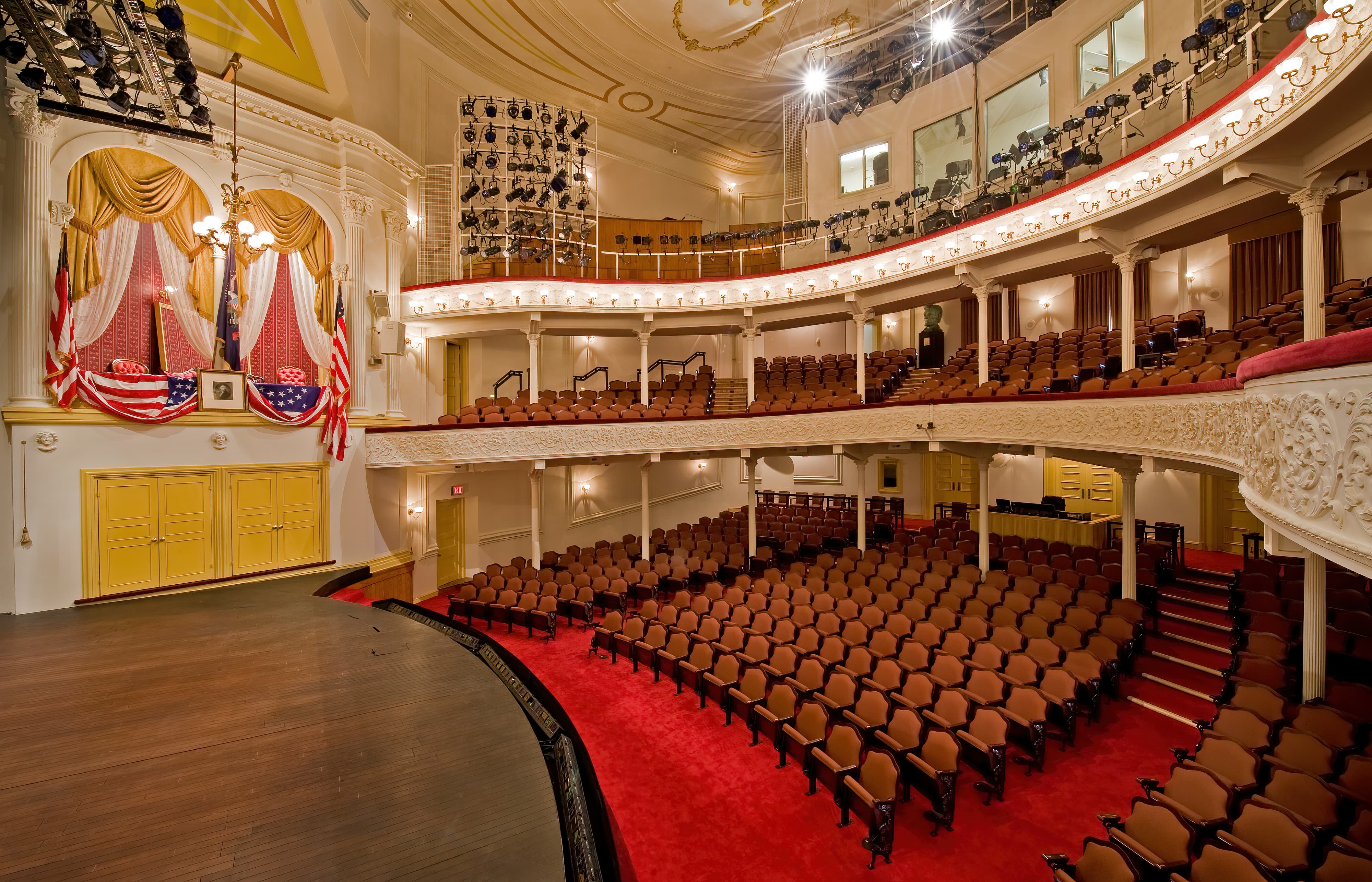 A large auditorium with rows of seats and a red carpet at Ford’s Theatre