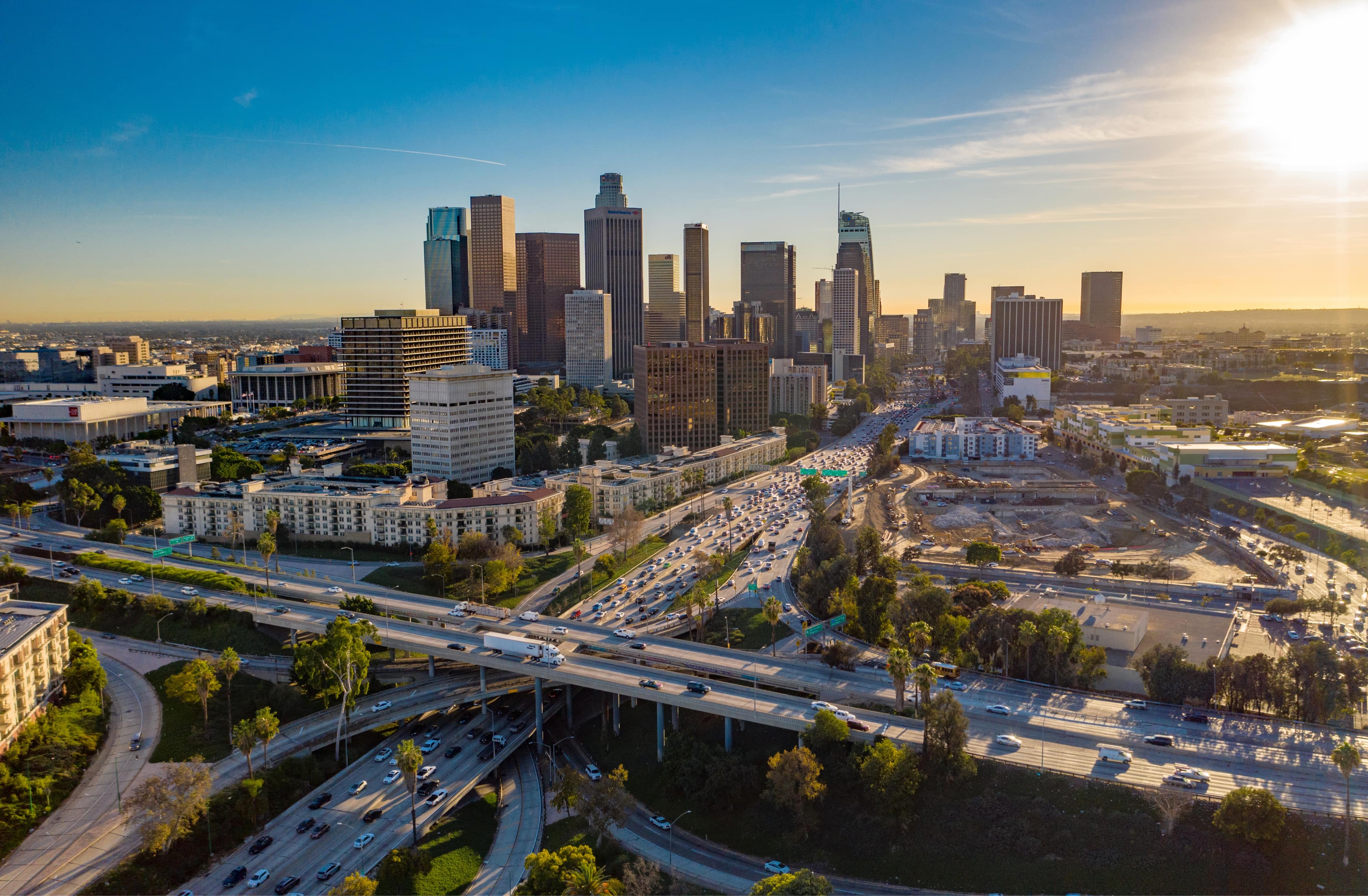 Drone view of downtown Los Angeles or LA skyline with skyscrapers and freeway traffic below